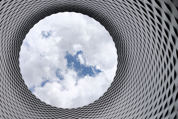 An image looking out of a circular structure pointed towards the sky.