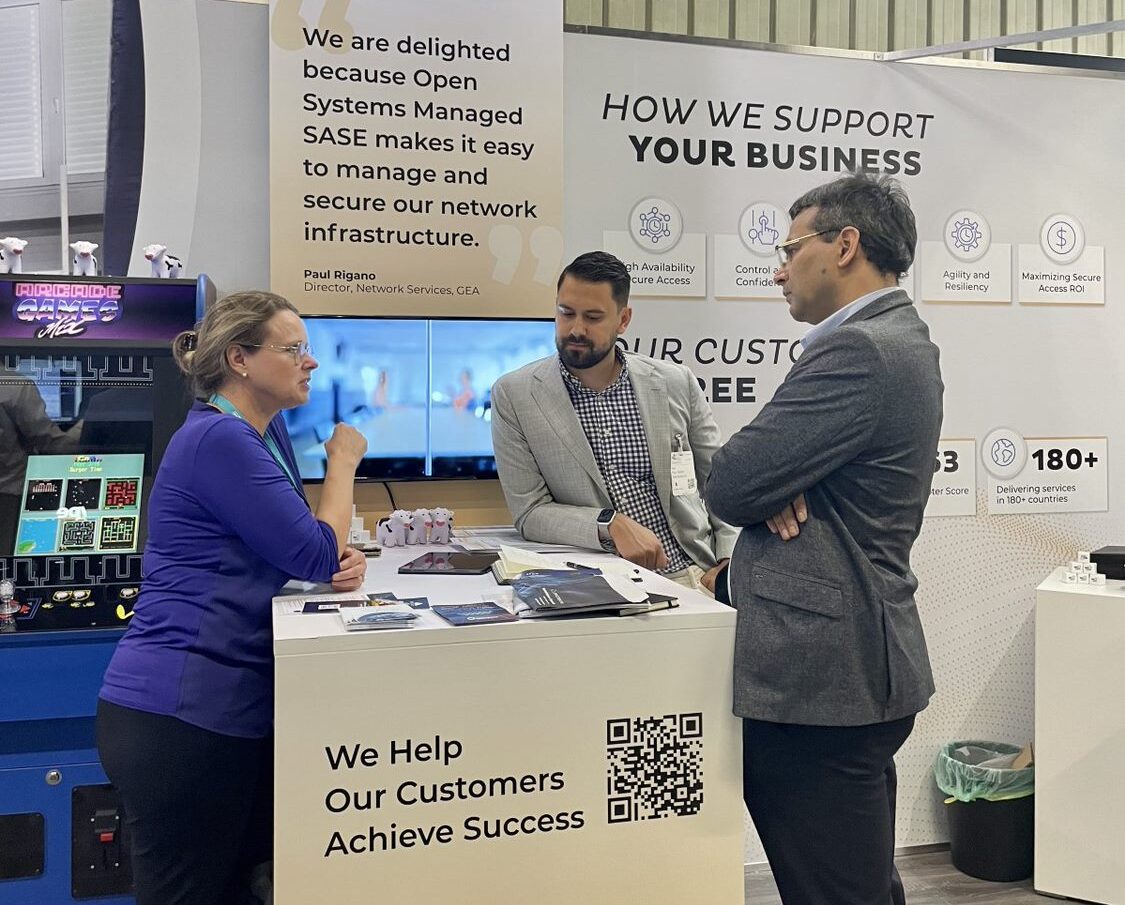 Open Systems employees speaking to prospective customers at their it-sa booth.